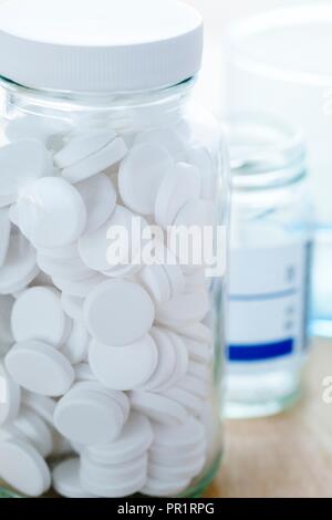 Weiße Pillen in einer Glasflasche. Stockfoto