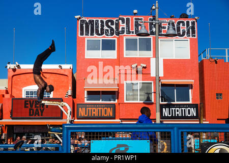 Venice Beach, Los Angeles, Kalifornien - 25. Februar 2018: Mann ausbildungszahlen vor orange Muscle Beach Gebäude Stockfoto