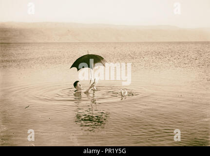 Um das Tote Meer. Mann floating mit Buch und Regenschirm in seinen Händen. 1925 Stockfoto