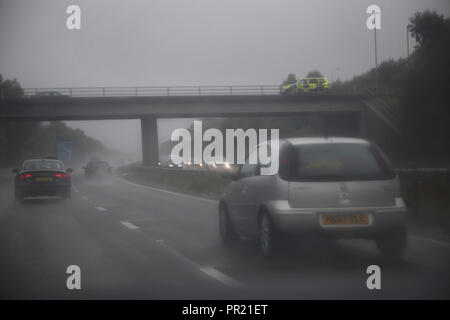 Verkehr In Heavy Rain auf M3 Polizei Auto auf Brücke Südengland Stockfoto