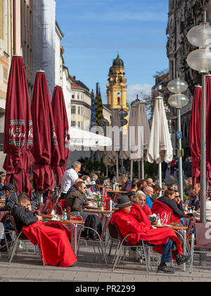 Gäste von outdoor Café am Marienplatz in München genießen Sie den Spätsommer Sonne mit Theatinerkirche im Hintergrund Stockfoto