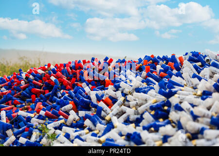 Shotgun shells auf blauen Himmel Hintergrund. Hintergrund der vielen bunten Schoß leer shotgun Shells, Blau, Rot, Gelb, Violett gefärbt Stockfoto