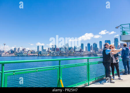 Seattle Washington City Skyline mit Fahrgästen im Vordergrund auf dem Deck der Fähre im Puget Sound geht nach Seattle, Washington Stockfoto