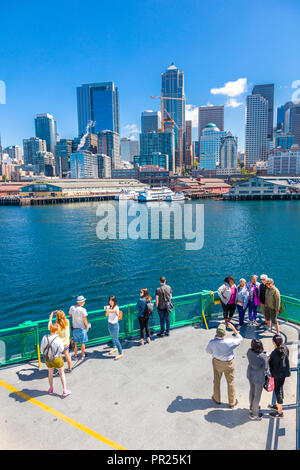 Seattle Washington City Skyline mit Fahrgästen im Vordergrund auf dem Deck der Fähre im Puget Sound geht nach Seattle, Washington Stockfoto