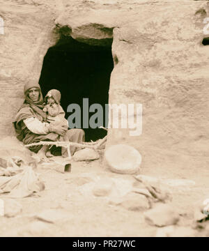Petrean Typen, etc. Petra. Bdul Höhlenwohnungen Araber. Mutter und Baby vor ihrer Höhle in ed-Der Tal. 1920, Jordanien, Petra Stockfoto