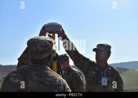 Spc. Charles Vincent montiert einen R8-Empfänger mit Sgt. Noel Smalls der 926th Engineer Battalion und SPC-Markierung Hathaway des HHC 926th Engineer Brigade hilft, die grade auf einem beweglichen etablieren - Rail Zielsystem für eine nicht-standard live - Feuer. Der Empfänger ist ein stationäres GPS, dass der Standort erhält von einem Satelliten. Es ist immer montiert an einem bekannten Ort genaue Koordinaten zu erhalten. Sie sind zur Festlegung der Note für eine bewegliche Rail-Zielsystem an der nicht-standard live - Feuer bei Joint National Training Center, Cincu, Rumänien. Dieses Projekt ist ein Teil der Entschlossenen C Stockfoto