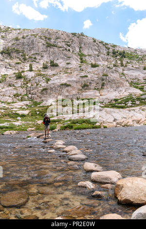 Ein Teenager backpacker Kreuze Evolution See Einlass. John Muir Trail/Pacific Crest Trail; Sequoia Kings Canyon Wilderness; Kings Canyon National Park; S Stockfoto