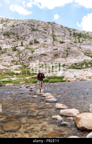 Ein Teenager backpacker Kreuze Evolution See Einlass. John Muir Trail/Pacific Crest Trail; Sequoia Kings Canyon Wilderness; Kings Canyon National Park; S Stockfoto