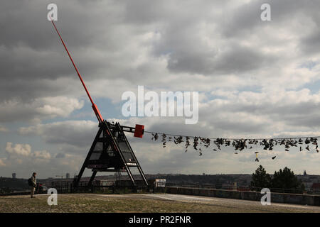 Prag Metronom (Pražský Metronom) durch tschechische Bildhauer Vratislav Karel Novák (1991) und alten Stiefel, hängen an der elektrischen Kabel in Letná Park (letenské Sady) in Prag, Tschechische Republik. Entsprechend lokaler Legende, Jugendliche werfen Schuhe auf dem Kabel, wenn sie ihre Jungfräulichkeit verlieren. Stockfoto