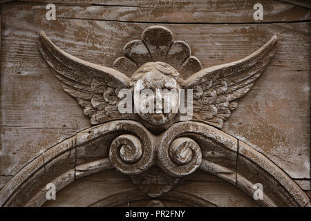 Engel in die hölzerne Relief an der Tür des Wohnhauses aus dem 20. Jahrhundert in Ovenecká Straße im Stadtteil Holešovice in Prag, Tschechische Republik. Stockfoto