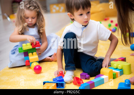 Männliche und weibliche Kinder spielen mit konstruktor im Kindergarten Stockfoto