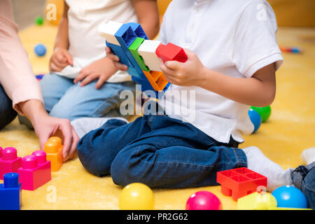 Zugeschnittenes Bild von Tutor und Kinder spielen mit konstruktor im Kindergarten Stockfoto