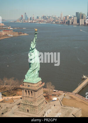 Die Freiheitsstatue mit Manhattan im Hintergrund von einem Helikopterflug über New York Bay gesehen Stockfoto