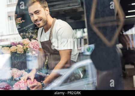 Blick durch die Fenster der stattlichen Florist kümmert sich um Die Zustellung der Blumen in Flower Shop Stockfoto