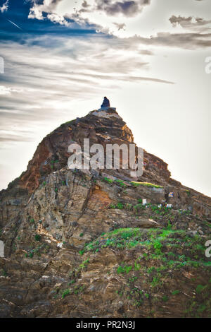 Person sitzt auf der Spitze eines Berges Stockfoto