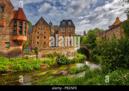 Malerische Stream mit grünen Flora entlang es durch Dean Village in Edinburgh fließen mit alten schottischen Gebäude Stockfoto