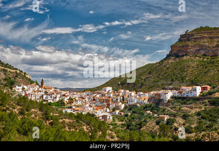 Die gesamte Stadt Chelva, Spanien in einer bergigen Canyon Area mit strahlend blauem Himmel und Wolken wie aus dem Wege hinter sich gesehen Stockfoto