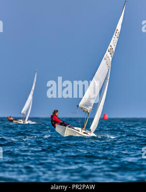 Wettbewerber auf dem blauen Mittelmeer racing einzelnen Finn Segelboote mit der roten Markierung drehen, um in der Ferne Stockfoto