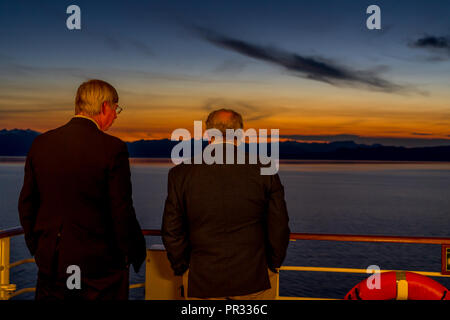 Juneau, Alaska, USA - 20.August 2018. Zwei ältere Männer bewundern schöne Sonnenuntergang vom Deck eines Kreuzfahrtschiffes Stockfoto