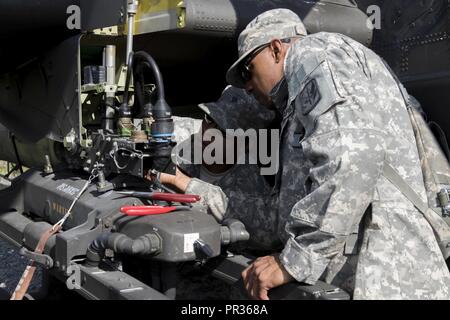 Spc. Kourtland Slater und Sgt. Robert Ricks, mit 1St Bataillon, 130 Luftfahrt, North Carolina Army National Guard, passt die Waffen Auswurf kostenlos auf einem AH-64D Apache Kampfhubschrauber am Joint Readiness Training Center, Fort Polk, Louisiana, 22. Juli 2017. Stockfoto