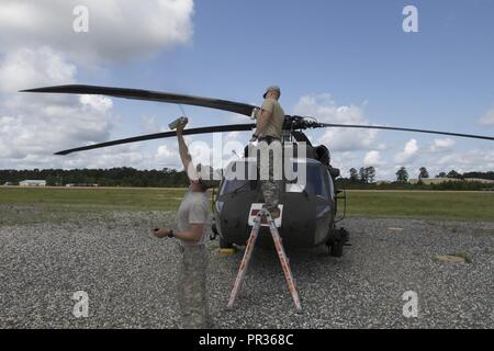 Spc. Kellen Brehm und Pfc. Kyle Laidlaw, mit Unternehmen C, 1.BATAILLON, 168 Luftfahrt, Colorado Army National Guard, sprühfarbe die Rotoren eines UH-60 Black Hawk am Joint Readiness Training Center, Fort Polk, Louisiana, 22. Juli 2017. Stockfoto