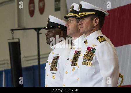 NORFOLK, Virginia (28. Juli 2017) (von links) Command Master Chief USS Harry S. Truman (CVN 75), Command Master Chief Antonio Perryman; Eingehende kommandierenden Offizier, USS Harry S. Truman, Kapitän Nicolas Dienna und Ausrückende kommandierenden Offizier, USS Harry S. Truman, Kapitän Ryan B. Scholl stand auf der Aufmerksamkeit, während Segler die Farben Parade während der Truman Ändern des Befehls Zeremonie in den Hangar Bay. Truman hosted eine Änderung der Befehl auf dem 19. Jahrestag der Inbetriebnahme des Schiffes. Stockfoto