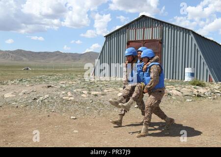 Mongolische Soldaten der Bundeswehr tragen eine fiktiv verletzten Soldaten während der Übung Khaan Quest 2017 auf fünf Hügeln, Mongolei, 28. Juli 2017 zur Sicherheit. Übungen wie Khaan Quest die Bühne für die teilnehmenden Länder gegenseitig von Erfahrungen zu lernen friedenserhaltenden Kapazität zu erhöhen. Stockfoto