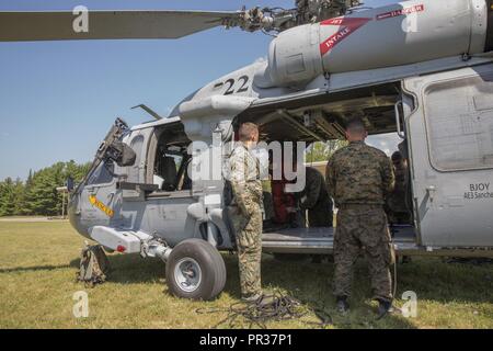 CAMP ÄSCHE, Mich - US-Marines von Echo Company, 4 Reconnaissance Battalion, 4th Marine Division, Marine Reserve, für eine helocast Übung von einem US-Marine Sikorsky SH-60 Seahawk vom Meer Combat Squadron 22 Vorbereiten, am Lager Äsche gemeinsame Manöver Training Center, Michigan, während der übung Northern Strike 17, 31. Juli 2017. Helocasting ist eine zerstreute Technik von kleinen Einheiten und spezielle Funktionen für den Einsatz in militärischen Bereichen eingesetzt. Übung Northern Strike ist ein National Guard Bureau - geförderte Ausbildung übung, vereint Service Mitglieder aus mehreren Branche Stockfoto