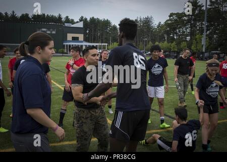 Us Marine Corps Staff Sgt. Miguel Castro schüttelt die Hand eines Teilnehmers des Sports Leadership Academy - Boston Fußball-Programm in den Vordergrund tritt in Taunton, Massachusetts, 22. Juli 2017. Die Akademie ist ein kostenloses Programm, High School Athleten angeboten, ihre Fußball-Fähigkeiten und gewinnen Führung Wissen aus der lokalen Marine recruiters zu steigern. Castro ist das Personal noncommissioned Officer Leiter Recruiting Unterstation Framingham, Mass. Stockfoto