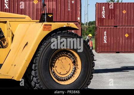 Us-Armee finden Sgt. Kelvin Torbinio, einer Ladung Fachmann mit der 1182Nd Bereitstellung und Distribution Support Bataillons, führt eine mi-jack Railstacker laden Frachtcontainer bei Pads in Military Ocean Terminal Sunny Punkt, N.C., auf eine M-878 Lkw im Rahmen der Operation Trans Mariner 17., 30. Juli 2017 inszeniert. Während der Operation, Transport Spezialisten erleichtern die Übertragung von Zubehör und Munition für Einheiten, die in der ganzen Welt. Stockfoto