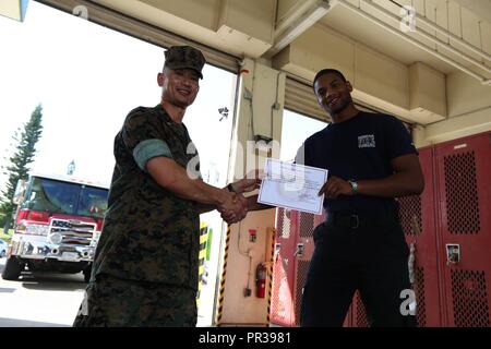 CAMP COURTNEY, Okinawa, Japan - Oberstleutnant Pat S. Vongsavanh, Links, und Petty Officer 3rd Class Elgie E. McCoy Jr. posieren für ein Foto in der Feuerwehr 31. Juli an Bord Camp Courtney, Okinawa, Japan. McCoy kam zu einer verzweifelten Frau in Arbeit am 16. Juli in der Feuerwehr. Er half ihr, das Kind mit Hilfe von zwei Feuerwehrmänner liefern. Nach dem Baby geliefert wurde, die Männer sicher transportiert die glückliche Familie an der US Naval Hospital Okinawa an Bord Camp Foster. Drei Zertifikate der Anerkennung wurden die Männer, die eine Mutter ihr Baby sicher liefern half vorgestellt. Ich Vongsavanh Stockfoto