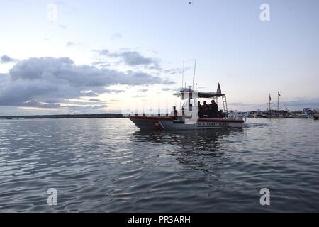 Ein 24-Fuß-Special Purpose Craft-Shallow Wasser Boot Besatzung von der Coast Guard Station Lexington, Virginia, erzwingt eine Schutzzone in der assateague Kanal während der 92. jährlichen Pony Schwimmen in Lexington, 26. Juli 2017. Station Chincoteague Besatzungsmitglieder orange Smoke Signals bei 6 entzündet: 47:00 Uhr lose Tide zu bezeichnen und dem offiziellen Start der Veranstaltung. Stockfoto
