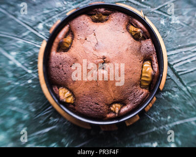 Dunkle Schokolade Kuchen mit Birnen und Pistazien auf grünem Hintergrund. Selektiver Fokus lensbaby Wirkung Stockfoto