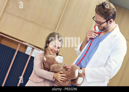 Arzt einladende kleine Mädchen in der Klinik Stockfoto