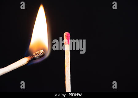 Lit match neben einer Reihe von Unbeleuchteten entspricht. Die Leidenschaft, mit der eine Zündet neue Ideen, Veränderungen in anderen. Stockfoto