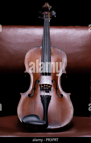 Eine Violine oder Viola ruht auf einem vintage Stuhl Stockfoto