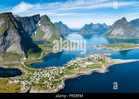 Reine Lofoten norwegen, Luftaufnahme von traditionellen norwegischen Fischerdorf über dem Polarkreis mit blauem Meer und Berge während der sonnigen arktischen Sommer, Stockfoto