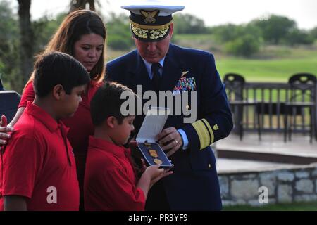 Hintere Adm. Dave Callahan, 8 Coast Guard District Commander, präsentiert die Gold Lifesaving Medal zur Familie der pensionierte Marine Corps Master Sgt. Rodney Buentello Juli 31, 2017, in San Antonio. Die Medaille ehrt Buentello der heldenhafte Taten in die Rettung von zwei Jugendlichen aus dem rauschenden Wasser der Medina River am Nachmittag des 8. Juni 2016. Us-Küstenwache Stockfoto