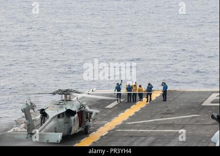 Pazifik (31. Juli 2017) Segler in die Luft Abteilung an Bord der Amphibisches Schiff USS America (LHA 6) Direkte einem MH-60S Sea Hawk Hubschrauber zum "Wildcards" der Hubschrauber Meer Combat Squadron 23 auf dem Schiff Flight Deck zugewiesen. Amerika, Teil der Amerika Amphibious Ready Group, mit 15 Marine Expeditionary Unit eingeleitet, in der pazifischen Region Indo-Asia Partnerschaften zu stärken und dienen als ready-Response Force für jede Art von Kontingenz. Stockfoto