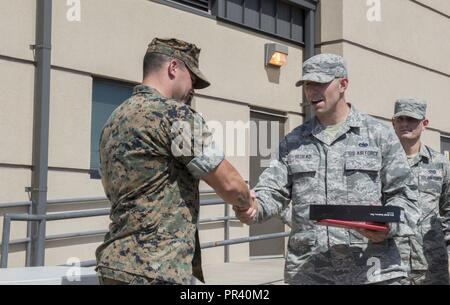 Us Air Force Tech. Sgt. Joseph Sedilko, 7 Logistik Bereitschaft Squadron Vehicle Operations Supervisor, präsentiert ein Geschenk des US Marine Corps Gunnery Sgt. Dominic Lombardo von Dyess Air Force Base, Texas, 28. Juli 2017. Lombardo war der Dank der Flieger half er durch die Marine Corps Martial Arts Programm. Stockfoto