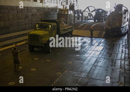 NORFOLK (25. Juli 2017) Matrosen und Marines guide Ausstattung wie sie geladen wird auf eine Landing Craft air cushion (LCAC) an Bord der amphibious Transport dock Schiff USS Arlington LPD (24) während einer Übung (LOADEX). Die Übung ist so konzipiert, Matrosen und Marines mit Krisenreaktionsfähigkeiten zu trainieren recovery Bemühungen zu unterstützen und die lokalen Behörden folgenden man-made und Naturkatastrophen unterstützen. Stockfoto