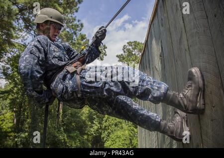 Ein U.S. Naval ROTC Midshipman rappels hinunter eine Wand während Karriere orientierte Ausbildung für die Midshipmen (CORTRAMID) Marine Woche, Camp Lejeune, N.C., 25. Juli 2017. Der Zweck der CORTRAMID ist es, den Studenten zu Chancen in der Fleet Marine zu entlarven und ein Interesse an einer Marine Corps Kommission generieren. Stockfoto