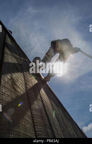 Ein U.S. Naval ROTC Midshipman rappels hinunter eine Wand während Karriere orientierte Ausbildung für die Midshipmen (CORTRAMID) Marine Woche, Camp Lejeune, N.C., 25. Juli 2017. Der Zweck der CORTRAMID ist es, den Studenten zu Chancen in der Fleet Marine zu entlarven und ein Interesse an einer Marine Corps Kommission generieren. Stockfoto