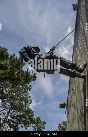 Ein U.S. Naval ROTC Midshipman rappels hinunter eine Wand während Karriere orientierte Ausbildung für die Midshipmen (CORTRAMID) Marine Woche, Camp Lejeune, N.C., 25. Juli 2017. Der Zweck der CORTRAMID ist es, den Studenten zu Chancen in der Fleet Marine zu entlarven und ein Interesse an einer Marine Corps Kommission generieren. Stockfoto