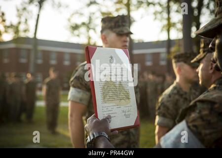 CAMP LEJEUNE, N.C. (September 5, 2018) US Marine Corps Sgt. Maj. Jeffrey Young, der Sergeant Major des 26 Marine Expeditionary Unit (MEU), liest eine Förderung rechtfertigen während der Werbeaktion Zeremonie in Camp Lejeune, N.C., September 5, 2018. Die 26. MEU Marines vor kurzem eine See-basierte Bereitstellung und wurden nach den Anforderungen für den aktuellen Rang befördert. Stockfoto