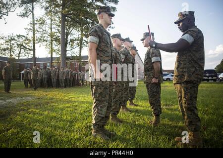 CAMP LEJEUNE, N.C. (September 5, 2018) US Marine Corps Sgt. Maj. Jeffrey Young, der Sergeant Major des 26 Marine Expeditionary Unit (MEU), liest eine Förderung rechtfertigen während der Werbeaktion Zeremonie in Camp Lejeune, N.C., September 5, 2018. Die 26. MEU Marines vor kurzem eine See-basierte Bereitstellung und wurden nach den Anforderungen für den aktuellen Rang befördert. Stockfoto