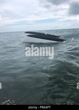 Eine gekentert 23-Fuß-Boot schwimmt im Wasser in der Nähe von Fort Pierce, Florida, 12.08.06, 2018. Ein Coast Guard Station Fort Pierce 33-Fuß-Special Purpose Craft-Law Durchsetzung boatcrew einen 63 Jahre alten Mann aus dem Rumpf seines umgeworfen Schiff gerettet, nachdem Sie einen Bericht aus einer Fort Pierce Brücke Ausschreibung eines gekenterten Schiffes anvisieren. Stockfoto