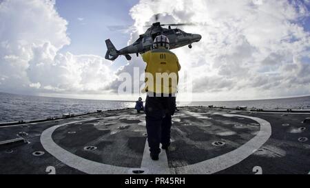 Petty Officer 1st Class Darla George, ein Coast Guard Cutter Tahoma Store Keeper, Signale einer mexikanischen Marine Helikopter ein Schweben über dem Schiff Flight Deck vor der Küste von Kolumbien an Sept. 7, 2018 durchzuführen. Diese Entwicklung war Teil der UNITAS, die aus einer Vielzahl von Übungen und multinationalen Austausch die Interoperabilität zu verbessern, die regionale Stabilität zu erhöhen, und bauen und regionale Beziehungen mit allen Ländern der Region weiterhin durch gemeinsame, multinationale und ressortübergreifende Austausch und Zusammenarbeit. Stockfoto