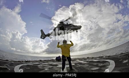 Petty Officer 1st Class Darla George, ein Coast Guard Cutter Tahoma Store Keeper, Signale einer mexikanischen Marine Helikopter ein Schweben über dem Schiff Flight Deck vor der Küste von Kolumbien an Sept. 7, 2018 durchzuführen. Die mexikanische Marine Hubschrauber durchgeführt die Antenne Manöver als Teil der jährlichen UNITAS Übung. Stockfoto