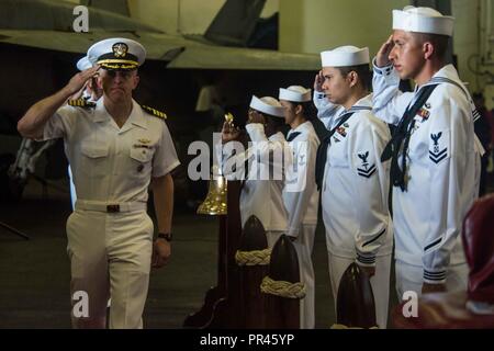 Philippinischen MEER (10. September 2018) Der zeremoniellen Bootsmann mate und sideboys render Ehren für Kapitän Patrick Hannifin, kommandierender Offizier der Marine vorwärts - bereitgestellt Flugzeugträger USS Ronald Reagan (CVN 76) bei einem Befehl Zeremonie an Bord des Schiffes. Hannifin entlastet Kapitän Michael Donnelly als Kommandierender Offizier der Ronald Reagan. Ronald Reagan, das Flaggschiff der Carrier Strike Group 5, bietet eine Bekämpfung bereit, Kraft, schützt und verteidigt die kollektive maritime Interessen seiner Verbündeten und Partnern in der indopazifischen Region. Stockfoto